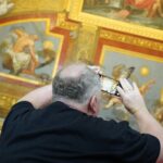 A man taking a picture of a ceiling with a cell phone